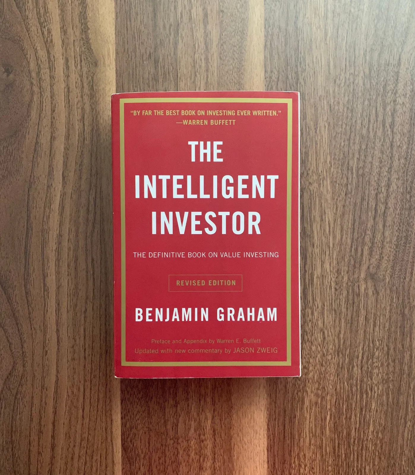 The Intelligent Investor book by Benjamin Graham on wooden table - Andy Crebar